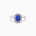 The Nahla Siri 14K Two Tone Tanzanite and Diamond Double Halo Ring features a large oval tanzanite center, double halo of white diamonds, and additional diamonds along the band.