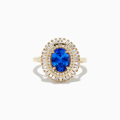 The Nahla Siri 14K Yellow Gold Tanzanite and Diamond Ring features an oval-cut tanzanite center with two halos of baguette and round diamonds, beautifully presented on a plain white background.