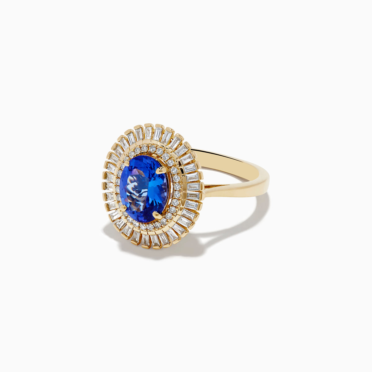 The Nahla Siri 14K Yellow Gold Tanzanite and Diamond Ring features an oval-cut tanzanite center with two halos of baguette and round diamonds, beautifully presented on a plain white background.