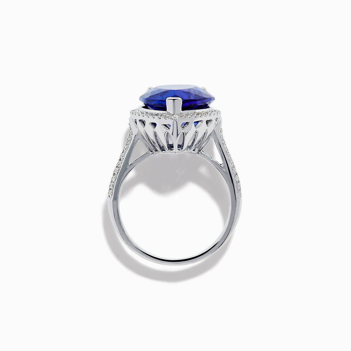 The 14K White Gold Pear Shape Tanzanite and Diamond Halo Ring features a pear-shaped blue tanzanite surrounded by a diamond halo on a delicate white gold band, displayed against a white background.