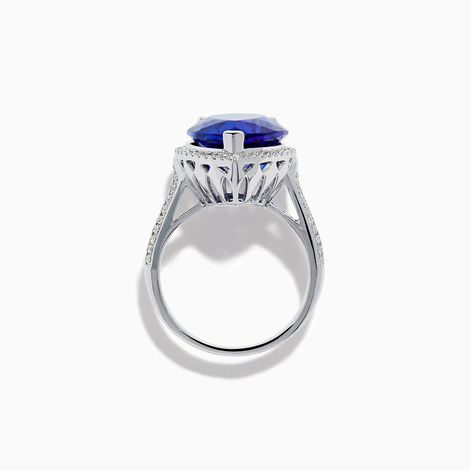 The 14K White Gold Pear Shape Tanzanite and Diamond Halo Ring features a pear-shaped blue tanzanite surrounded by a diamond halo on a delicate white gold band, displayed against a white background.