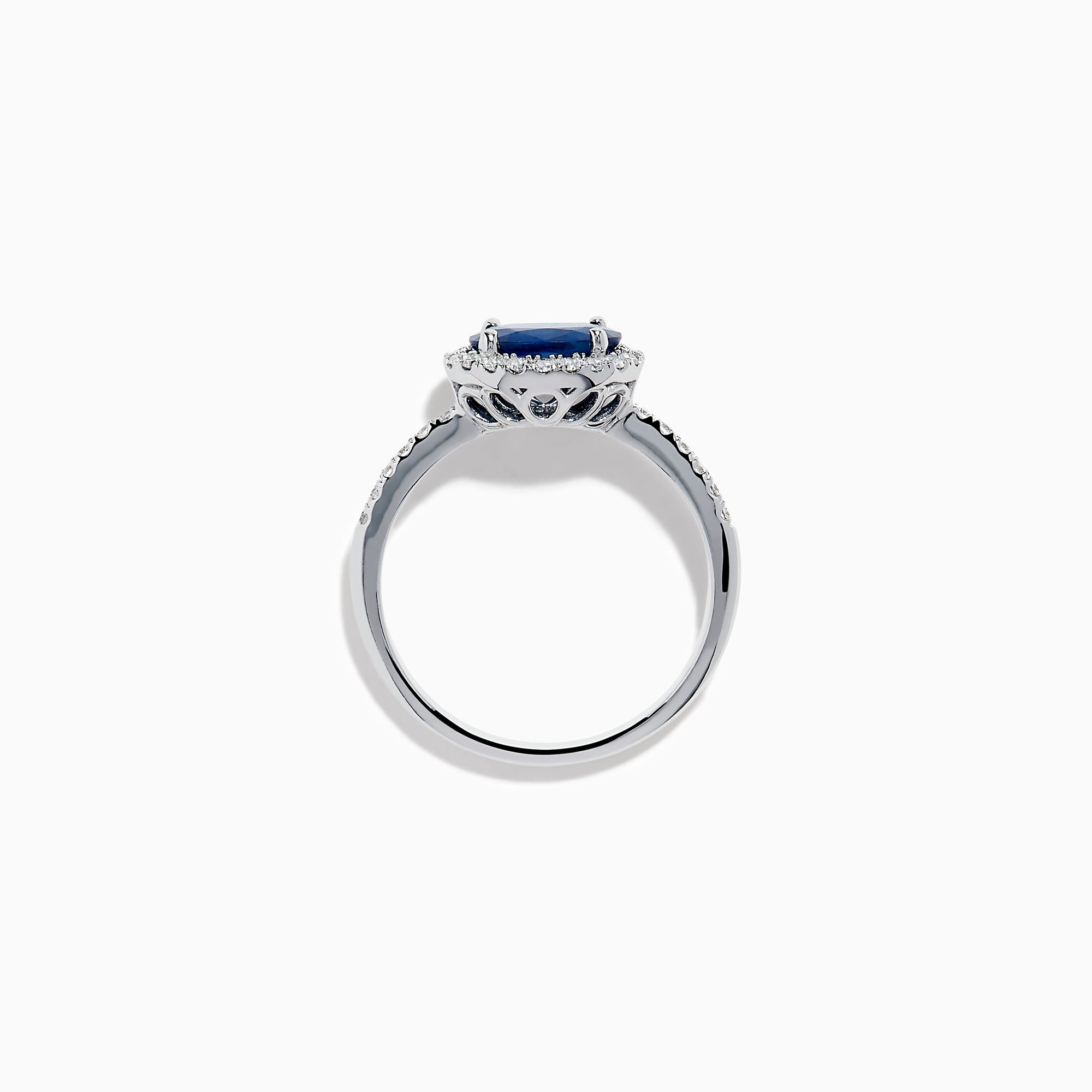 The 14K White Gold East West Oval Blue Sapphire and Diamond Halo Ring showcases an oval blue sapphire encircled by a diamond halo, with extra diamonds accenting the band for added brilliance.