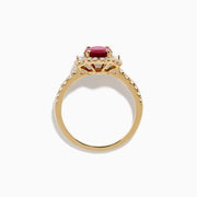 The Ruby Royale 14K Yellow Gold Ruby and Diamond 3 Stone Ring showcases a central oval ruby flanked by sparkling diamonds, set on a diamond-accented band and elegantly displayed against a white background.
