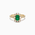 The Brasilica 14K Yellow Gold Emerald and Diamond Halo Ring features an emerald-cut green gemstone surrounded by a diamond halo, baguette-cut diamonds, and additional diamonds on the band.