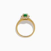 The Brasilica 14K Yellow Gold Emerald and Diamond Halo Ring features an emerald-cut green gemstone surrounded by a diamond halo, baguette-cut diamonds, and additional diamonds on the band.