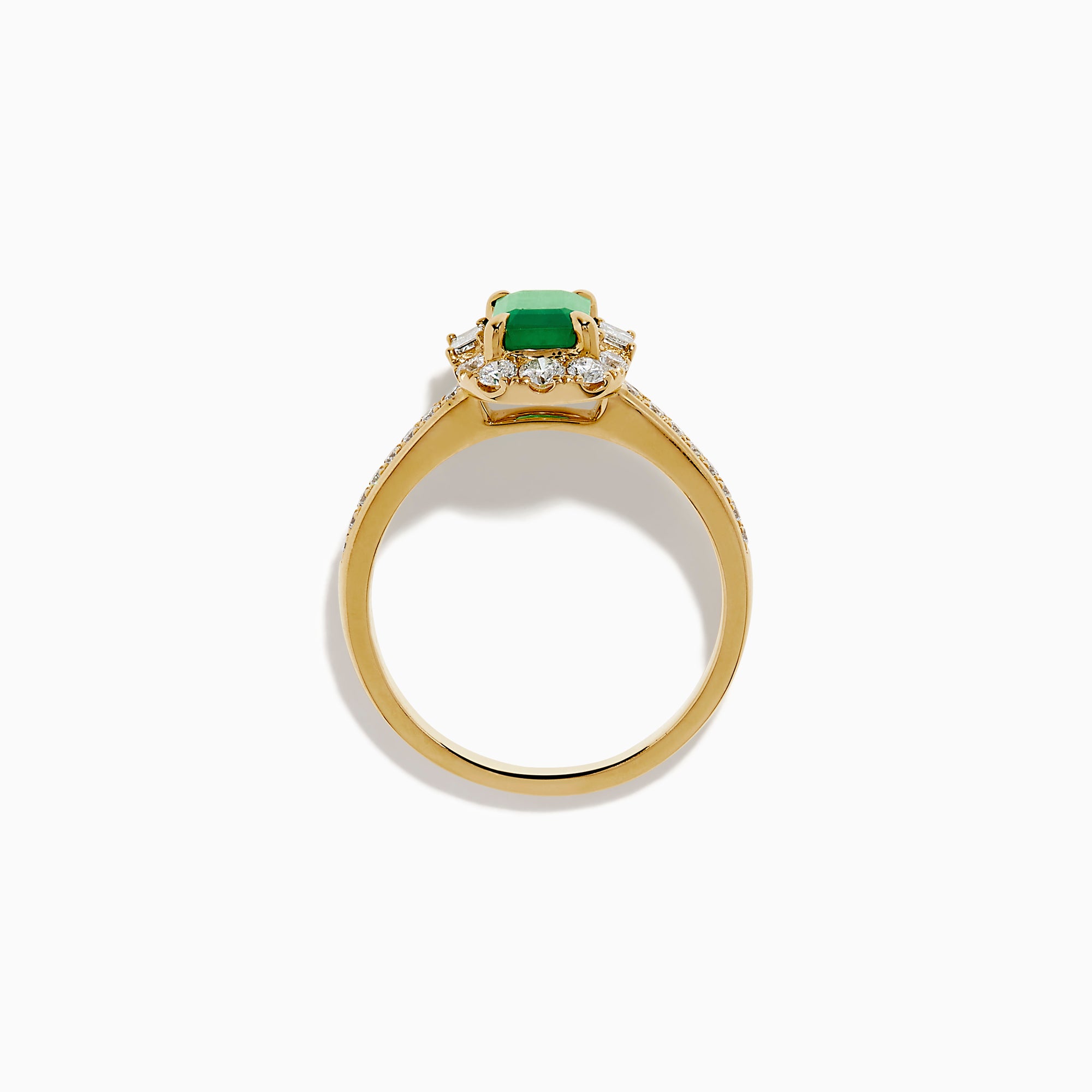 The Brasilica 14K Yellow Gold Emerald and Diamond Halo Ring features an emerald-cut green gemstone surrounded by a diamond halo, baguette-cut diamonds, and additional diamonds on the band.