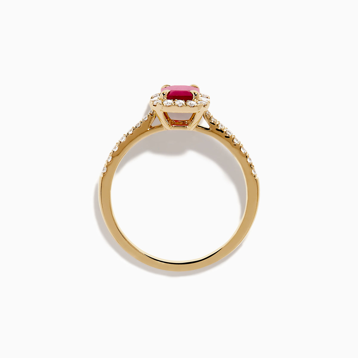 The Ruby Royale 14K Yellow Gold Ruby and Diamond Halo Ring features a rectangular ruby center, surrounded by a halo of round and baguette diamonds, with extra diamond accents on the band for added brilliance.