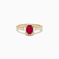 The 14K Yellow Gold Oval Ruby and Diamond Halo Ring features a central oval ruby surrounded by a sparkling diamond halo, with additional diamonds adorning the elegant band.