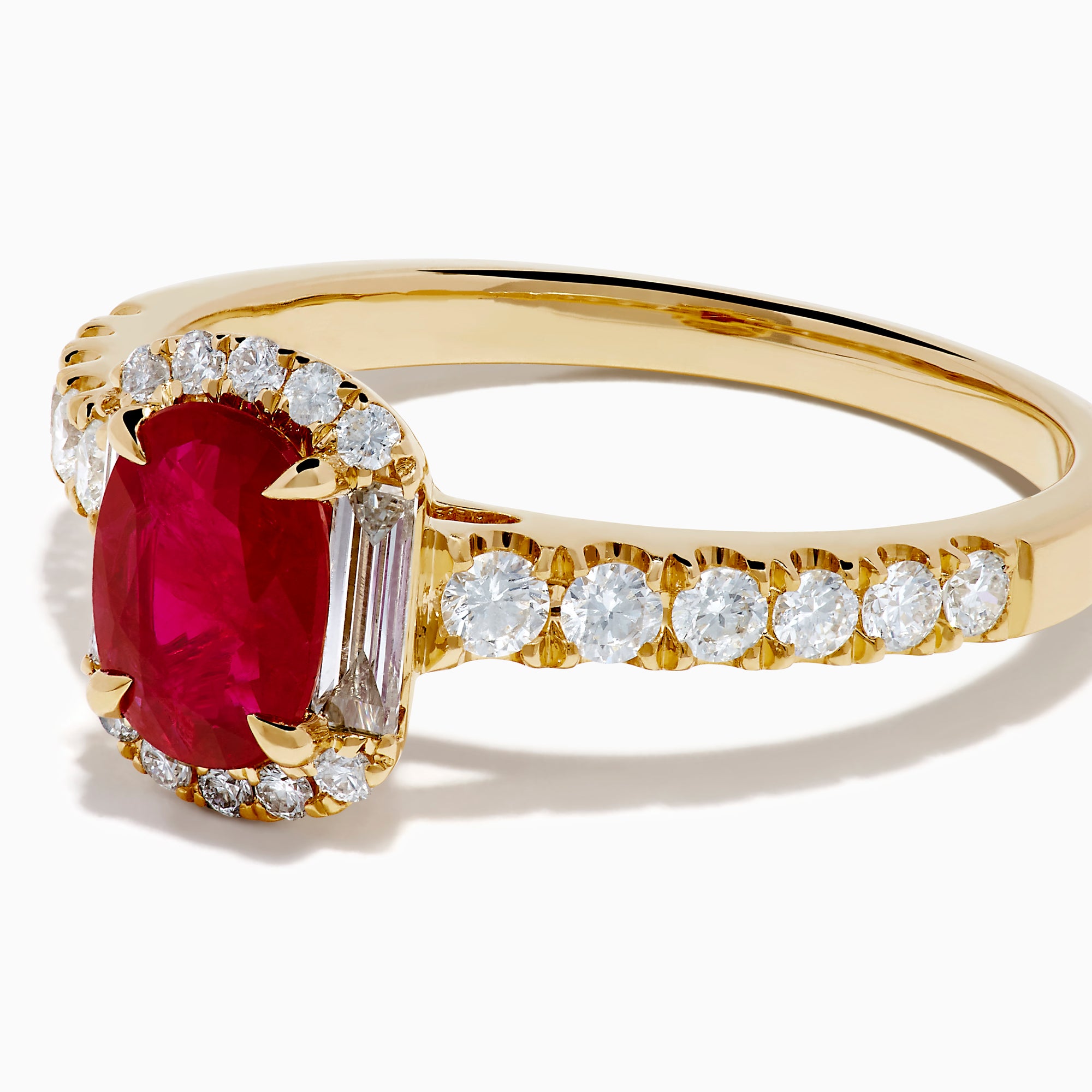 The 14K Yellow Gold Oval Ruby and Diamond Halo Ring features a central oval ruby surrounded by a sparkling diamond halo, with additional diamonds adorning the elegant band.