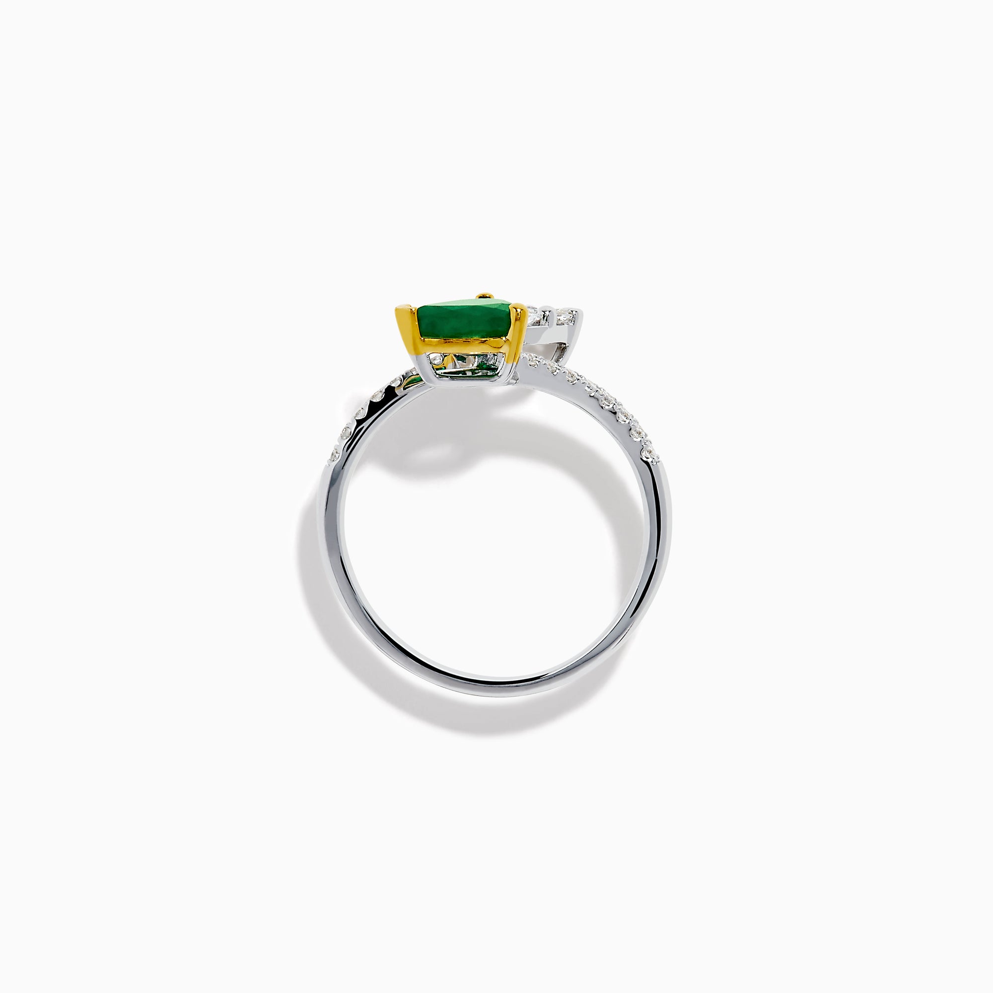 The 14K Two Tone Gold Emerald and Diamond Toi et Moi Ring features a pear-shaped green emerald and a pear-shaped white diamond, accented by sparkling small diamonds on the band.