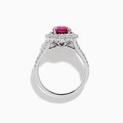 The 18K White Gold Pink Sapphire and Diamond Halo Ring features an oval pink sapphire surrounded by a diamond halo, with additional diamonds along the band for extra sparkle.