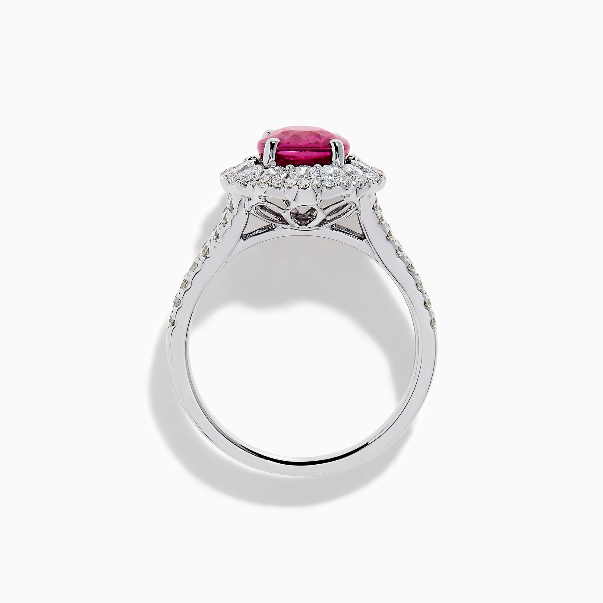 The 18K White Gold Pink Sapphire and Diamond Halo Ring features an oval pink sapphire surrounded by a diamond halo, with additional diamonds along the band for extra sparkle.