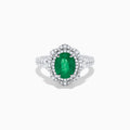 The 18K White Gold Emerald and Diamond Ring features an oval green emerald center stone, two diamond halos, and sparkling diamonds set along the band.