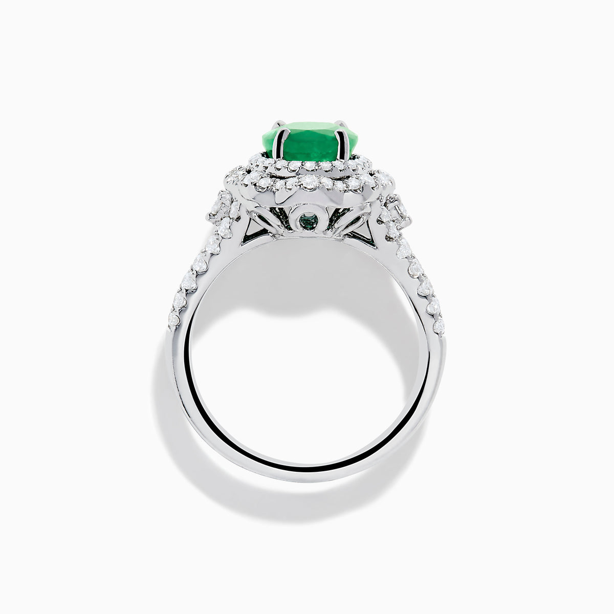 The 18K White Gold Emerald and Diamond Ring features an oval green emerald center stone, two diamond halos, and sparkling diamonds set along the band.