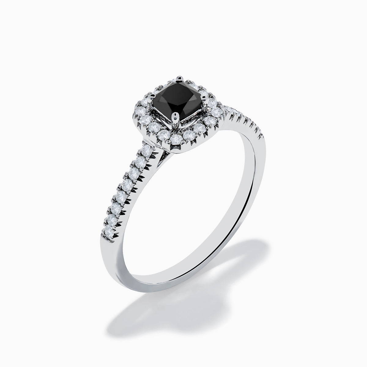 The 14K White Gold White and Black Diamond Halo Ring features a rectangular black center stone surrounded by white diamonds, with more diamonds along the band, all presented on a white background.