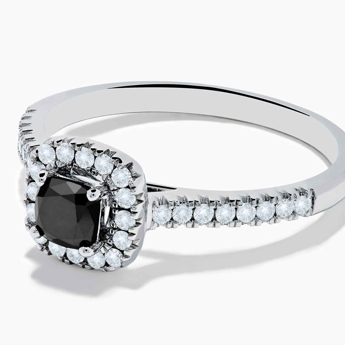 The 14K White Gold White and Black Diamond Halo Ring features a rectangular black center stone surrounded by white diamonds, with more diamonds along the band, all presented on a white background.