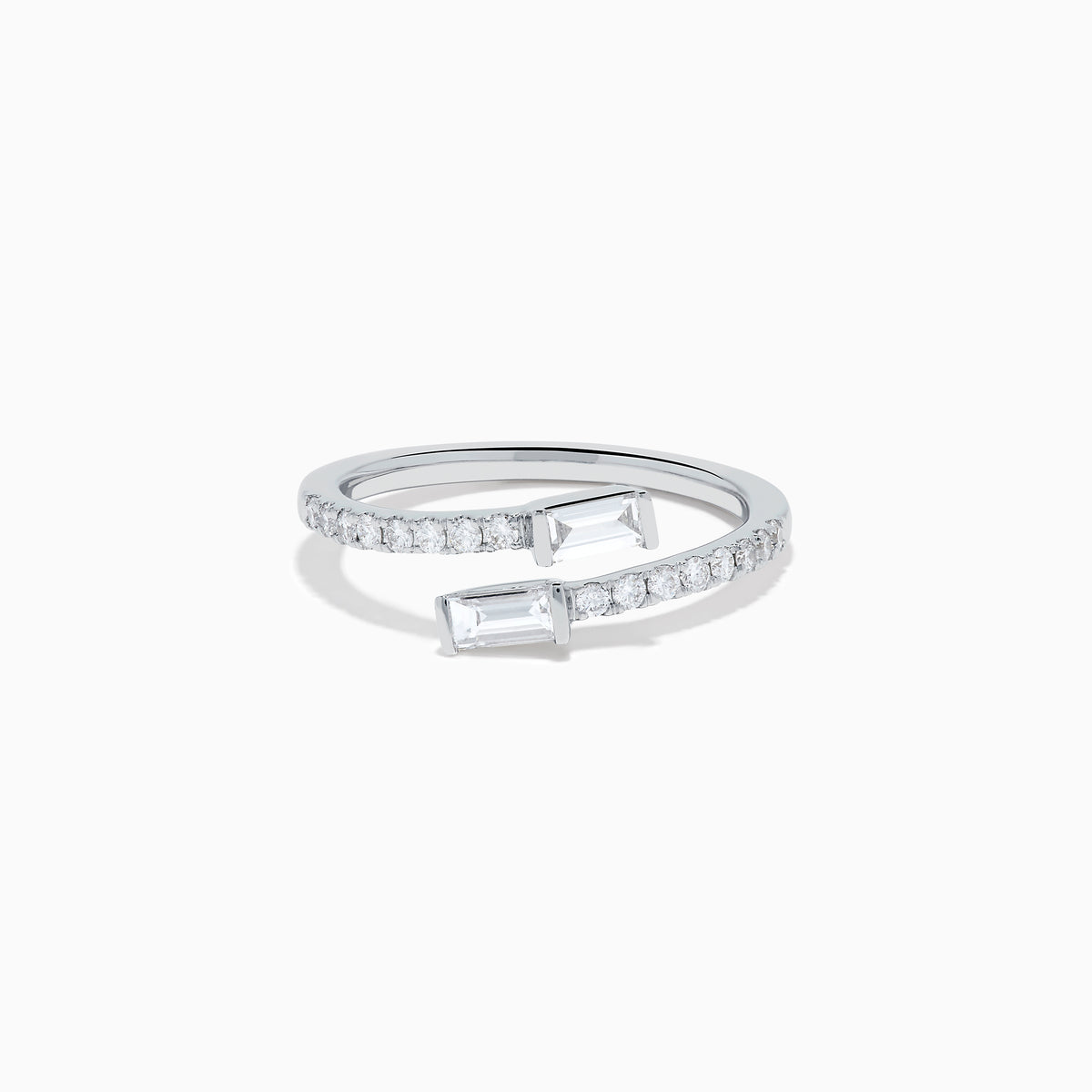The 14K White Gold Diamond Bypass Ring features two rectangular baguette-cut diamonds at each end and a row of small round diamonds along the band, beautifully set against a white background.