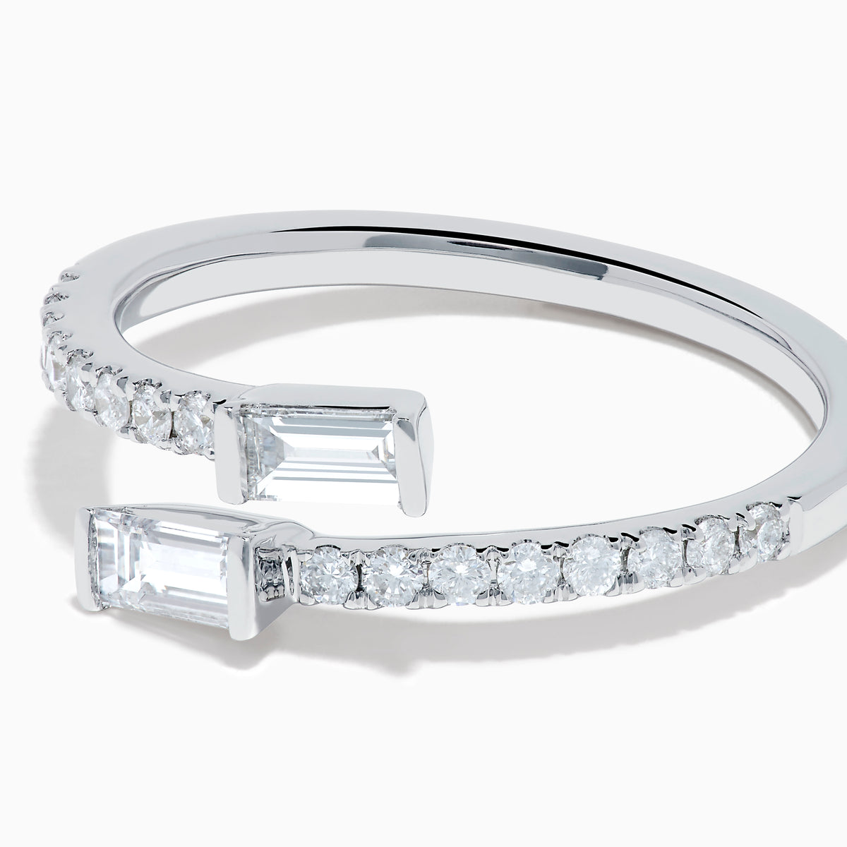 The 14K White Gold Diamond Bypass Ring features two rectangular baguette-cut diamonds at each end and a row of small round diamonds along the band, beautifully set against a white background.