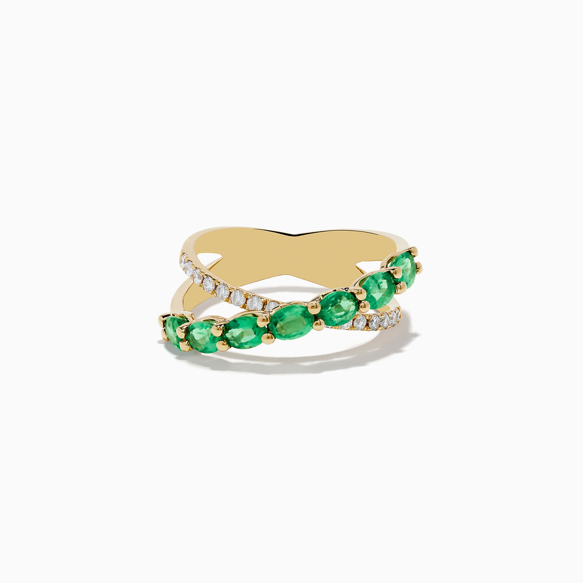 The Braslica 14K Yellow Gold Emerald and Diamond Crossover Ring showcases two crisscrossing bands—one set with round emeralds, the other with sparkling white diamonds—against a white background.