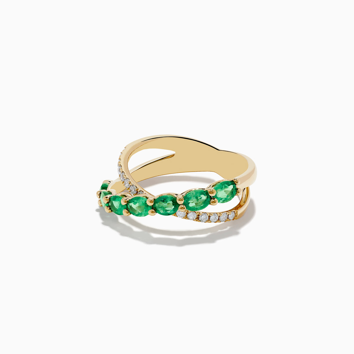 The Braslica 14K Yellow Gold Emerald and Diamond Crossover Ring showcases two crisscrossing bands—one set with round emeralds, the other with sparkling white diamonds—against a white background.
