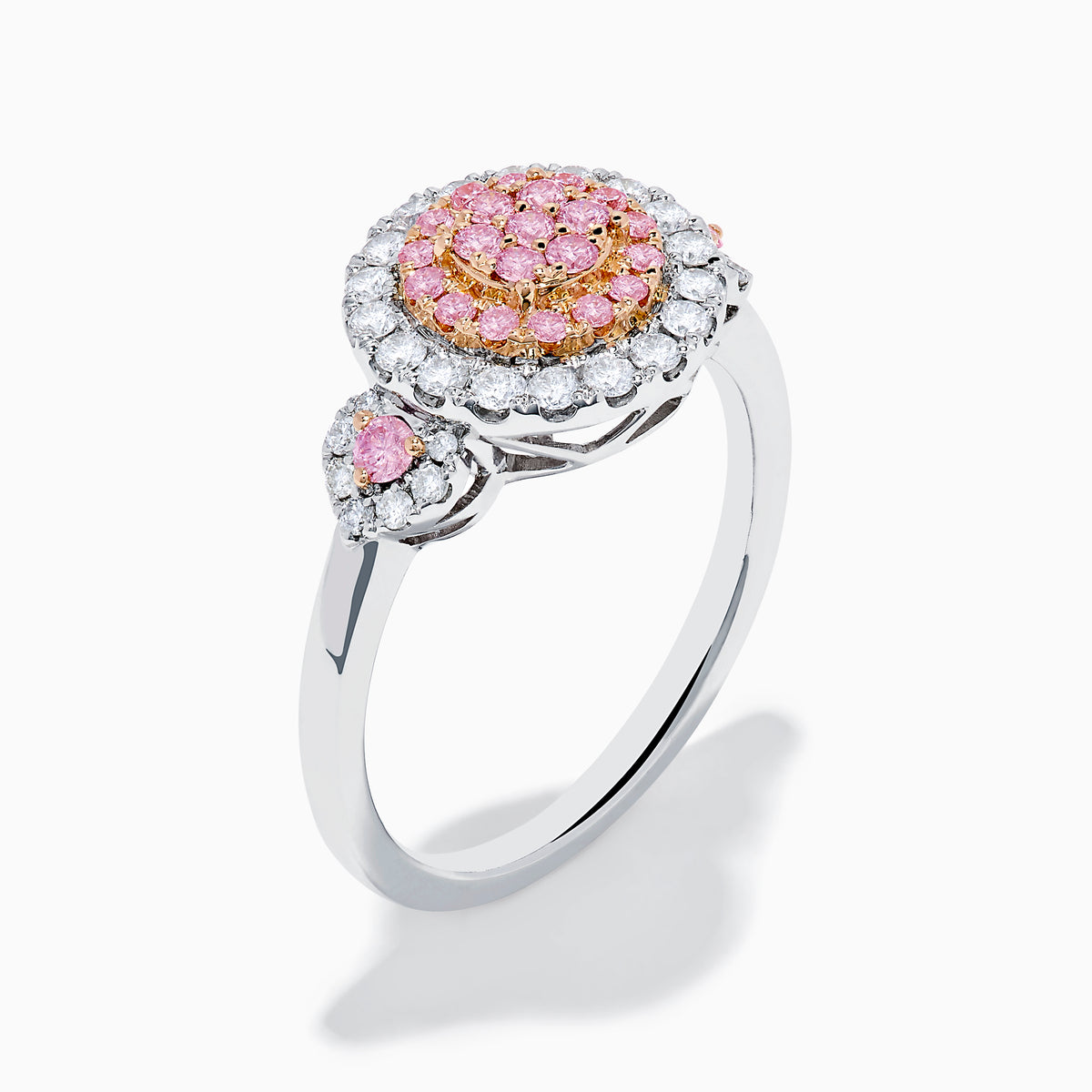 The 14K Two Tone Gold White and Pink Diamond Cluster Ring features a round cluster of pink diamonds at the center, encircled by white diamonds, with additional pink stones on each side for extra elegance.