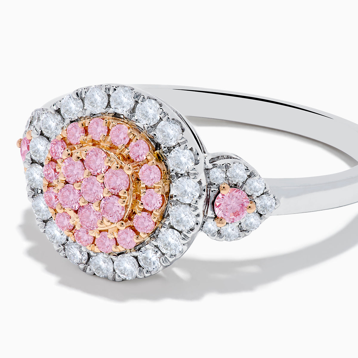 The 14K Two Tone Gold White and Pink Diamond Cluster Ring features a round cluster of pink diamonds at the center, encircled by white diamonds, with additional pink stones on each side for extra elegance.