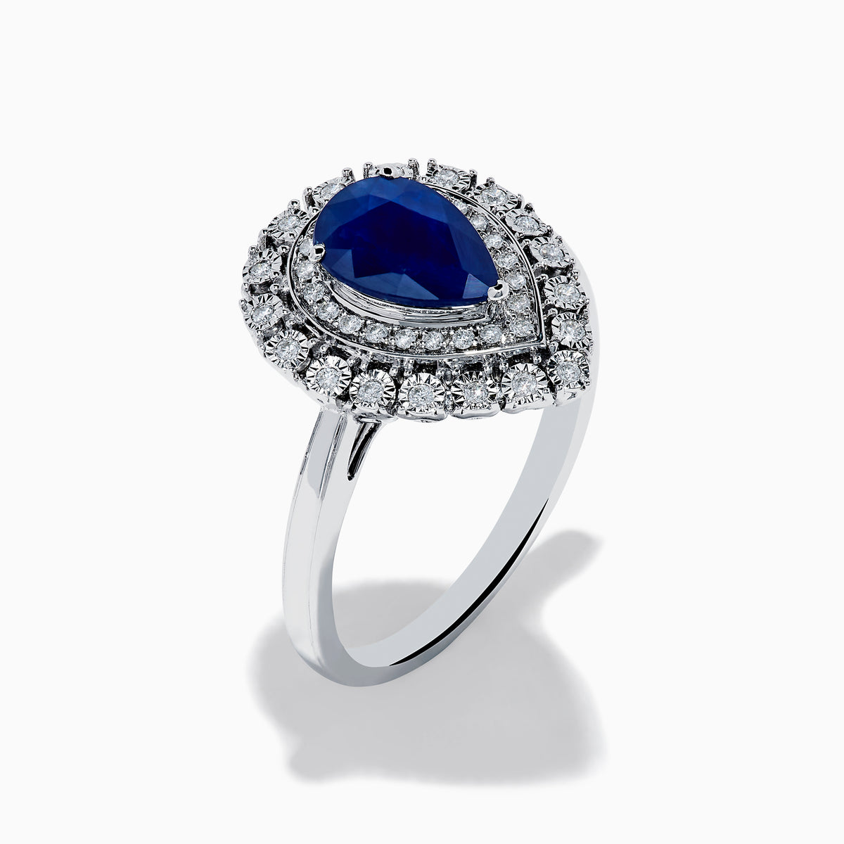 The Royale Bleu 14K White Gold Sapphire Diamond Ring showcases a pear-shaped sapphire center, encircled by two rows of sparkling round white diamonds in an elegant teardrop halo design.