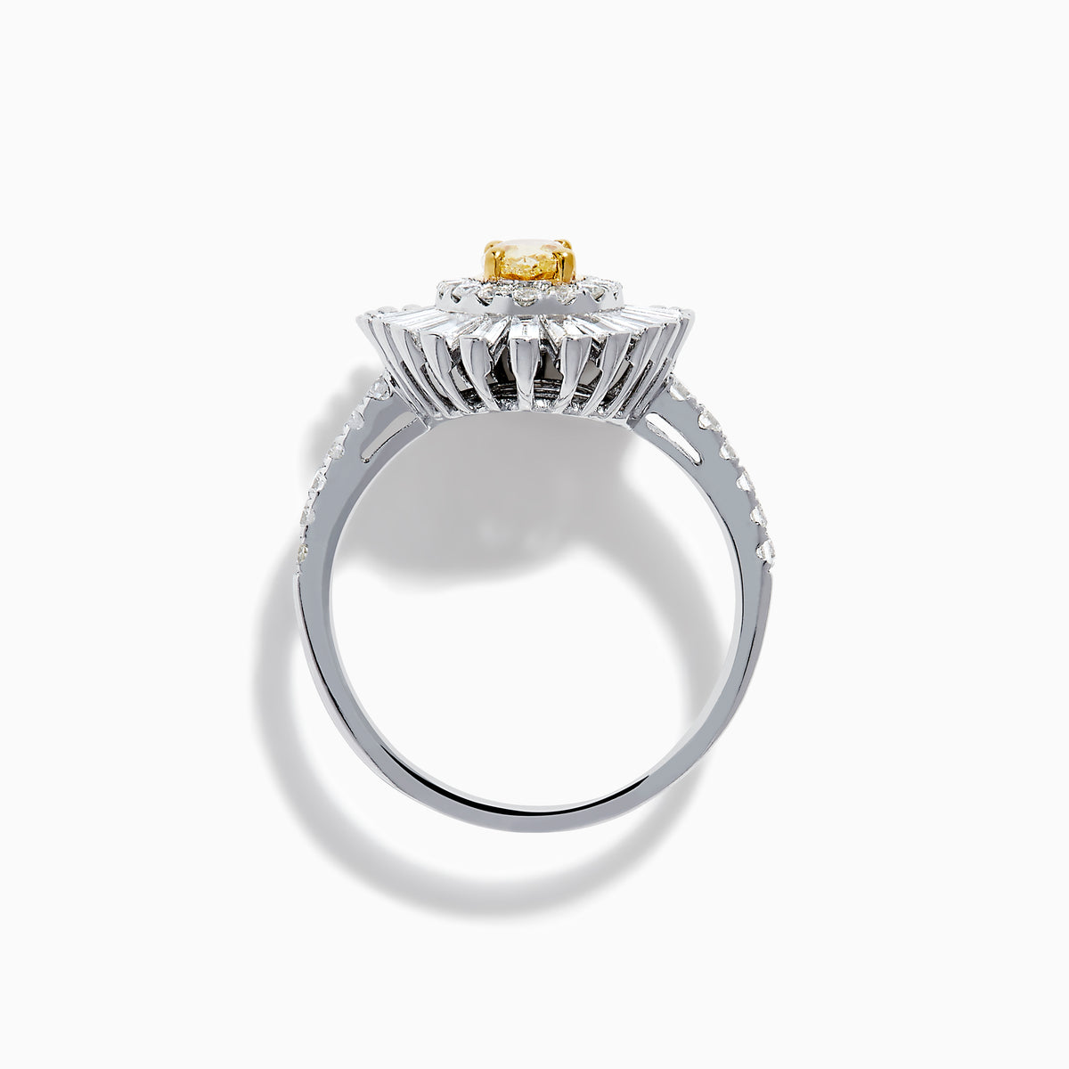 The Canare 18K Two Tone Gold Yellow and White Diamond Ring features an oval yellow centerpiece with a starburst halo of round and baguette white diamonds on a slim, diamond-studded band.