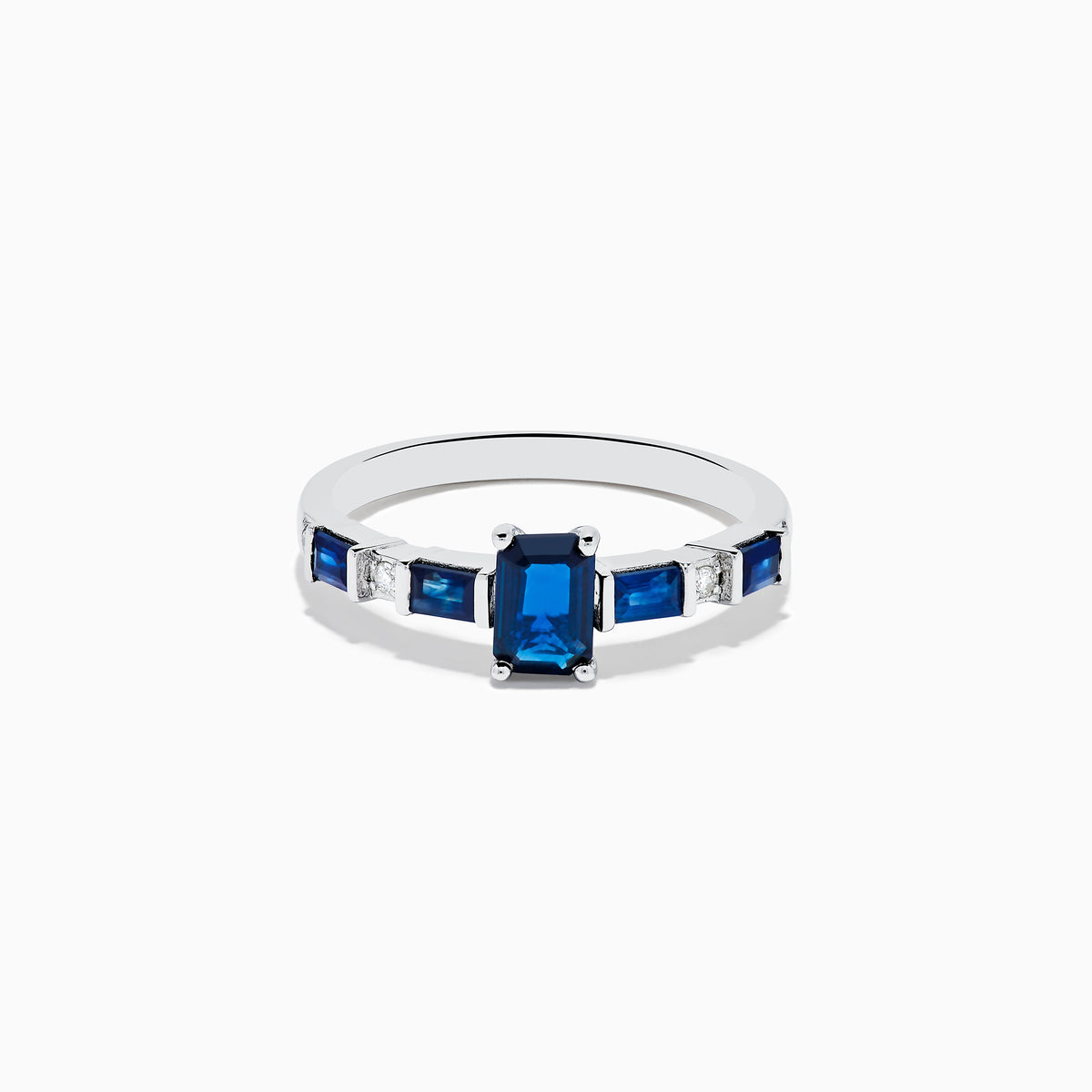 The Royal Bleu 14K White Gold Blue Sapphire and Diamond Ring features a rectangular blue sapphire center, flanked by square blue stones and diamonds on a sleek band against a plain white background.
