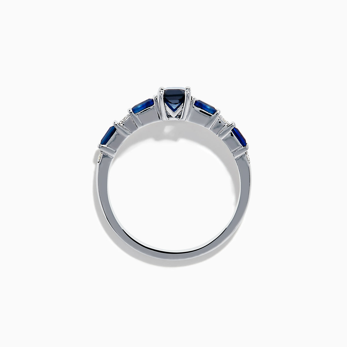 The Royal Bleu 14K White Gold Blue Sapphire and Diamond Ring features a rectangular blue sapphire center, flanked by square blue stones and diamonds on a sleek band against a plain white background.