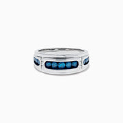 Men’s 14K White Gold Channel Set Blue and White Diamond Band featuring a row of round blue and white diamonds at the center, flanked by smaller white gems on each side, displayed on a white background.