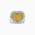 The Canare 18K Two Tone Gold Yellow Diamond Heart Ring, featuring a yellow diamond center with clear white stones on a silver band, is displayed against a white background.
