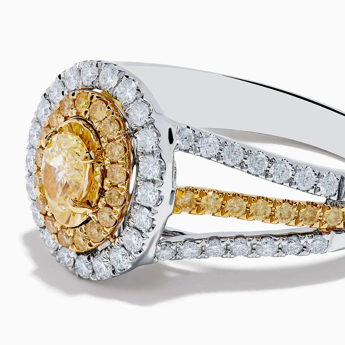 A close-up of the Canare 18K Two Tone Gold White and Yellow Diamond Ring, showcasing a yellow center stone in a halo of yellow and white diamonds on a split band with additional white and yellow diamonds.