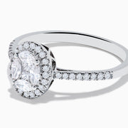 The Classique 14K White Gold Diamond Cluster Ring features an oval center diamond haloed by smaller diamonds, plus additional diamonds along its elegant band.
