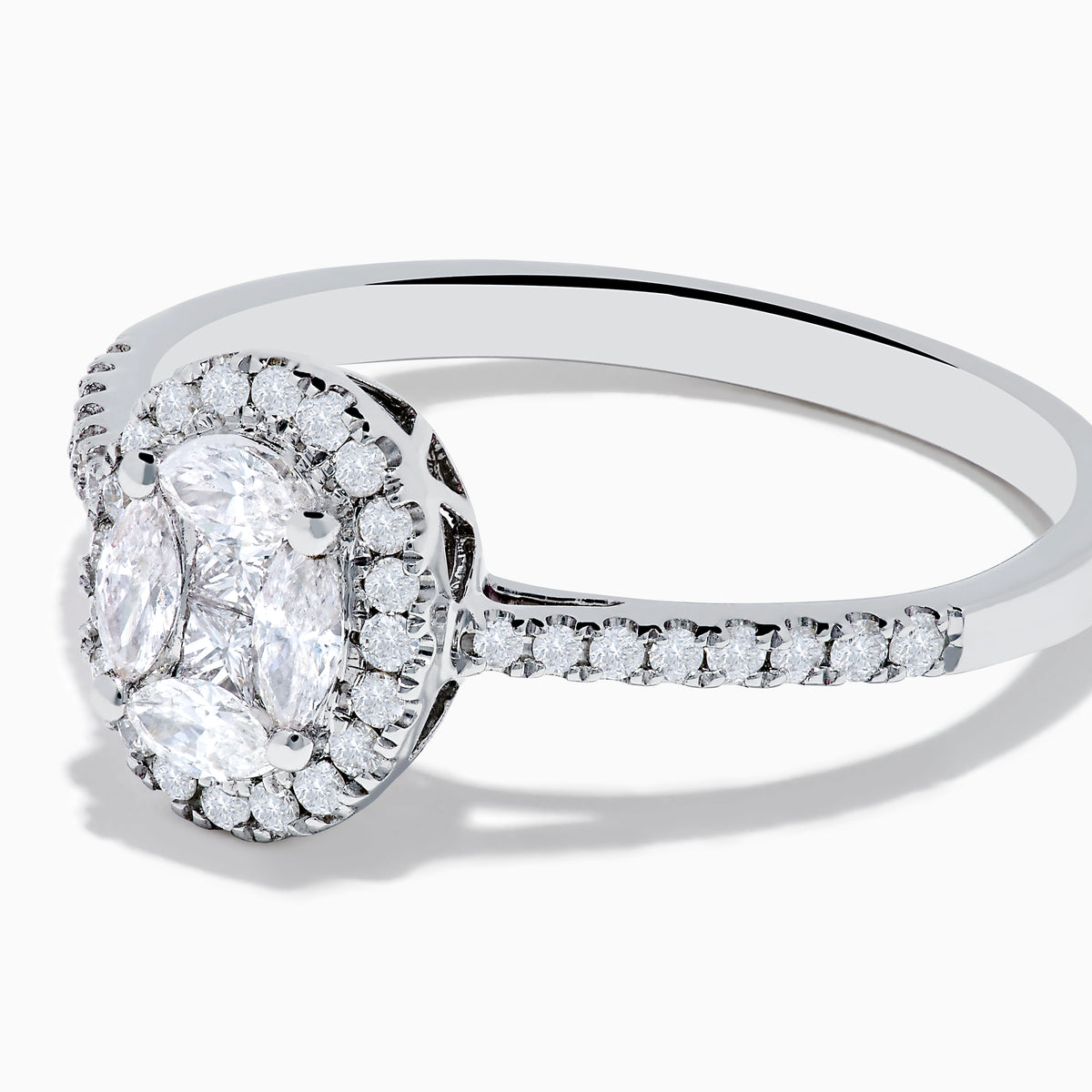 The Classique 14K White Gold Diamond Cluster Ring features an oval center diamond haloed by smaller diamonds, plus additional diamonds along its elegant band.