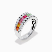 The Watercolors 14K White Gold Channel Set Multi Sapphire and Diamond Band showcases vibrant square-cut sapphires in a rainbow of colors, framed by sparkling round diamonds for a dazzling, colorful statement piece.