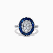 The Royal Bleu 14K White Gold Sapphire and Diamond Ring showcases an oval diamond cluster center, haloed by blue sapphires and accented with diamonds on the shoulders.