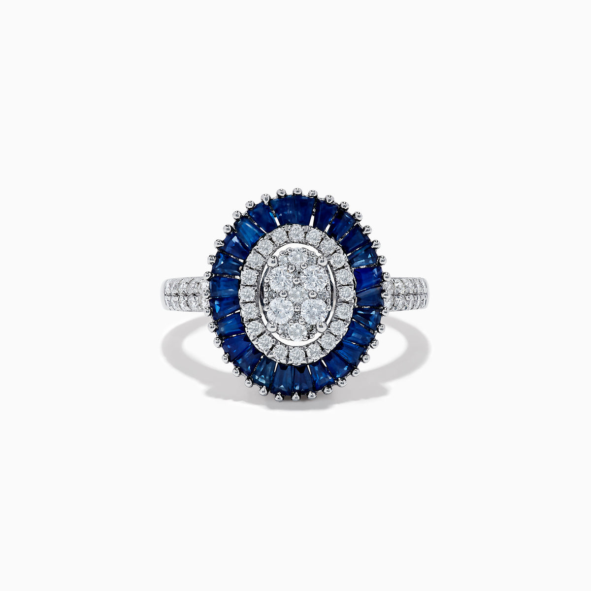 The Royal Bleu 14K White Gold Sapphire and Diamond Ring showcases an oval diamond cluster center, haloed by blue sapphires and accented with diamonds on the shoulders.