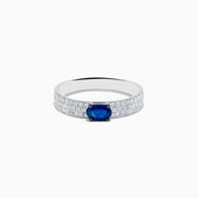 The Royal Bleu 14K White Gold Sapphire and Diamond Ring showcases an oval blue sapphire centerpiece with rows of small diamonds along the band, all set against a plain white background.