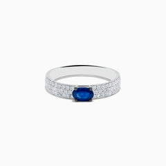 The Royal Bleu 14K White Gold Sapphire and Diamond Ring showcases an oval blue sapphire centerpiece with rows of small diamonds along the band, all set against a plain white background.