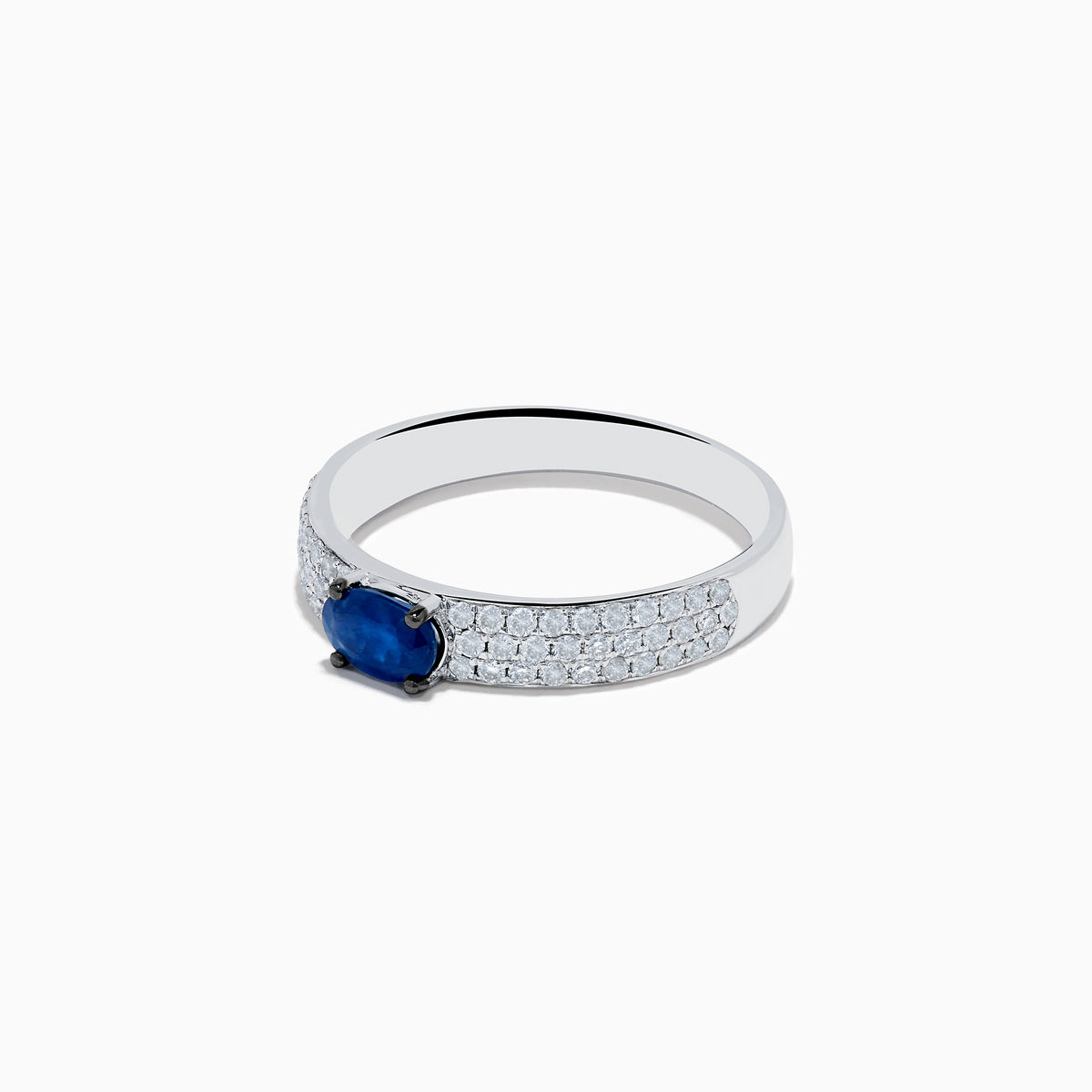 The Royal Bleu 14K White Gold Sapphire and Diamond Ring showcases an oval blue sapphire centerpiece with rows of small diamonds along the band, all set against a plain white background.