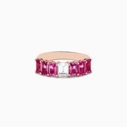 The 14k Rose Gold Pink and White Sapphire Ring features a central rectangular white sapphire, flanked by rectangular pink sapphires on each side, all set in rose gold and displayed against a white background.