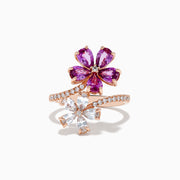 The Nature 14k Rose Gold Pink and White Sapphire Flower Diamond ring features two floral designs—one with pink sapphire petals, the other with white sapphires—set on a curved, stone-adorned band, shown against a white background.