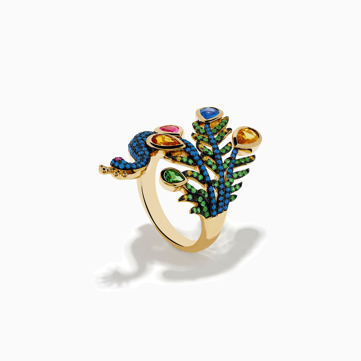 The Safari 14K Yellow Gold Multi Sapphire Peacock Ring features vibrant blue, green, yellow, pink, and orange sapphires with detailed feathers and a jeweled crown, set against a white background.