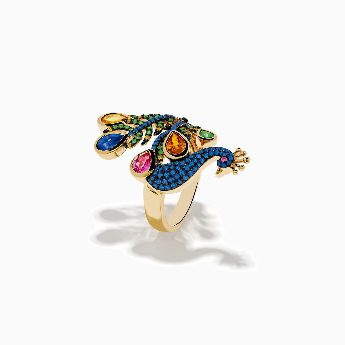 The Safari 14K Yellow Gold Multi Sapphire Peacock Ring features vibrant blue, green, yellow, pink, and orange sapphires with detailed feathers and a jeweled crown, set against a white background.