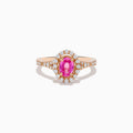 The 14K Rose Gold Pink Sapphire and Diamond Ring features an oval pink sapphire center, a halo of diamonds, and diamond accents on the band, all set against a white background.