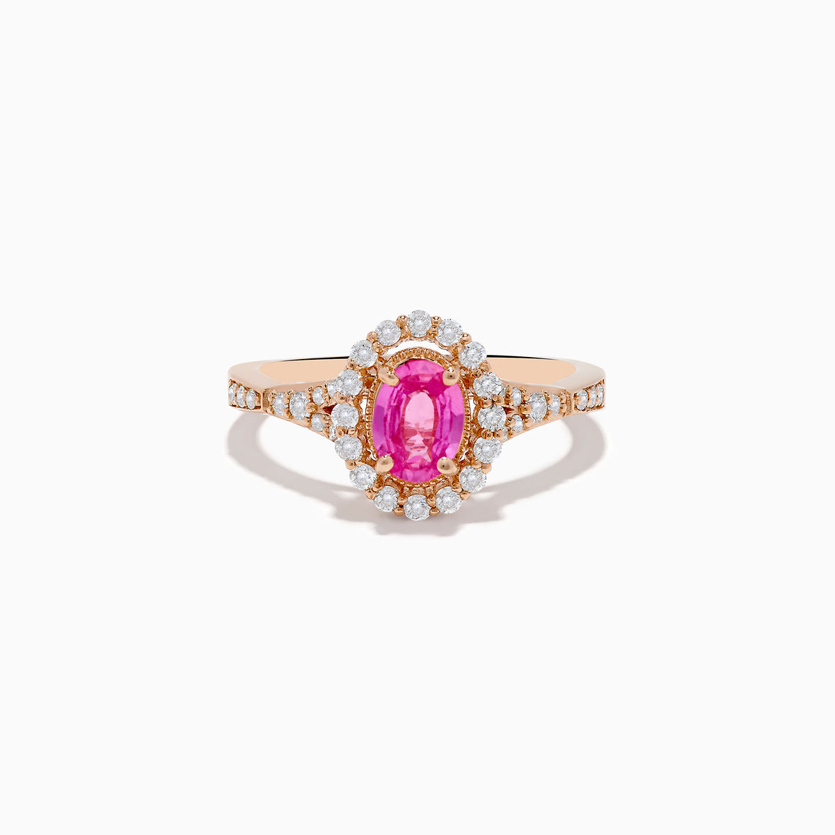 The 14K Rose Gold Pink Sapphire and Diamond Ring features an oval pink sapphire center, a halo of diamonds, and diamond accents on the band, all set against a white background.