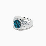 The Mens 14K White Gold Blue and White Diamond Ring features a round face with blue diamonds at the center, encircled by a border of sparkling white stones.