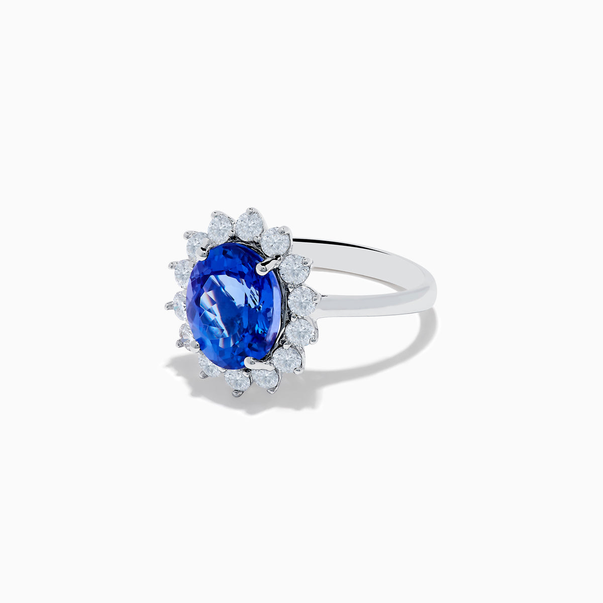 The Nahla Siri 14K White Gold Tanzanite and Diamond Ring showcases a large oval tanzanite center stone encircled by a halo of sparkling round white diamonds, all set in radiant 14K white gold.