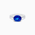 The Nahla Siri 14K White Gold Tanzanite and Diamond Ring features a large oval tanzanite center stone with smaller diamonds along the band, shown against a plain white background.